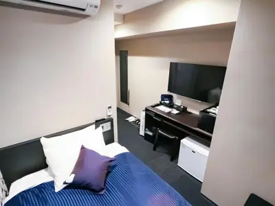 a hotel room with a bed and a desk at HOTEL LiVEMAX Tokyo-Otsuka Ekimae in Tokyo