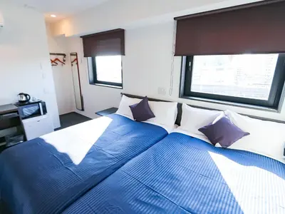 a bedroom with a large blue bed with pillows at HOTEL LiVEMAX Akabane-Ekimae in Tokyo