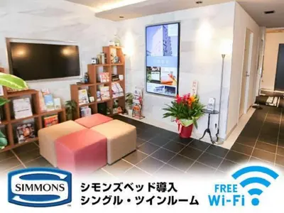 a living room with a couch and a tv at HOTEL LiVEMAX Akabane-Ekimae in Tokyo