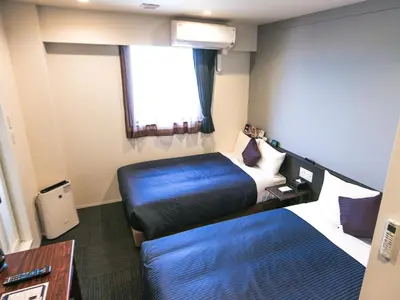 a hotel room with a bed and a window at HOTEL LiVEMAX Tokyo Ayase-Ekimae in Tokyo