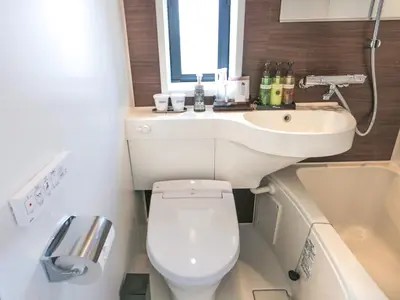 a small bathroom with a toilet and a sink at HOTEL LiVEMAX Tokyo Ayase-Ekimae in Tokyo