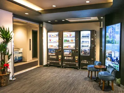 a lobby with four video game machines at HOTEL LiVEMAX Tokyo Ayase-Ekimae in Tokyo