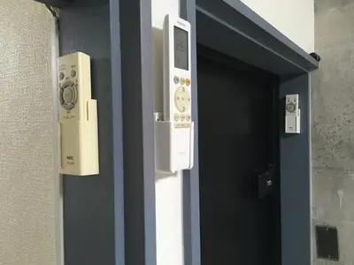 a door with two controls on the side of a building at 2F female and lover of man and woman only room in Ueno in Tokyo