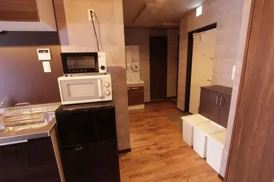 a kitchen with a microwave on top of a refrigerator at Shinjuku NY House 1 in Tokyo