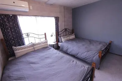 two beds in a room with a window at Shinjuku NY House 1 in Tokyo