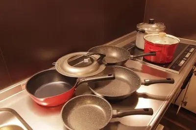 three pots and pans sitting on a stove top at Shinjuku NY House 1 in Tokyo