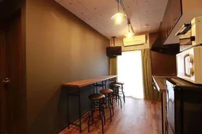 a kitchen with a bar with stools next to a window at Shinjuku NY House 1 in Tokyo