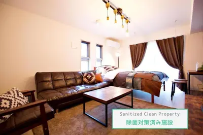 a living room with a leather couch and a bed at Prime Stage Otsuka Ikebukuro P203 in Tokyo