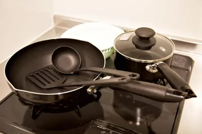 a pan with a spatula and a pot on a stove at Prime Stage Otsuka Ikebukuro P203 in Tokyo