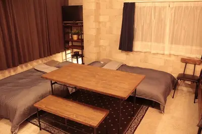 two beds in a room with a table and benches at ACT Residence No.1 201 in Tokyo