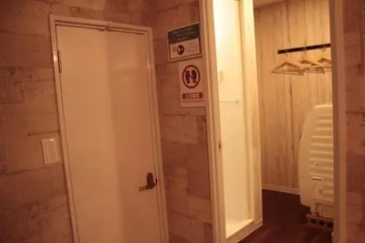 a bathroom with a shower with a white door at ACT Residence No.1 201 in Tokyo