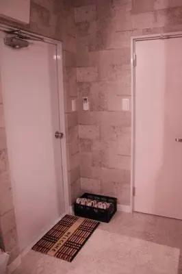 a bathroom with a door and a rug in front of a shower at ACT Residence No.1 201 in Tokyo