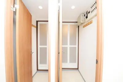 a walk in closet with white walls and glass doors at Shinjuku NY House 2 in Tokyo