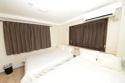 two beds in a room with two windows at Shinjuku NY House 2 in Tokyo