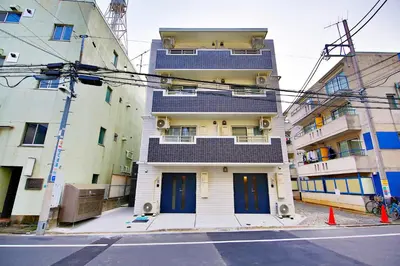a tall building with blue doors on a city street at Prime Stage Otsuka/Ikebukuro P204 in Tokyo