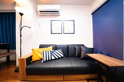 a black couch with pillows on it in a room at Hotel Atelier Tokyo in Tokyo