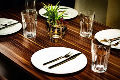a wooden table with white plates and glasses on it at Hotel Atelier Tokyo in Tokyo