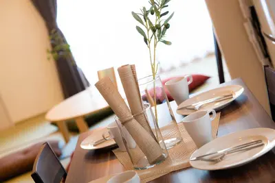 a wooden table with napkins and utensils on it at Hotel Atelier Tokyo in Tokyo
