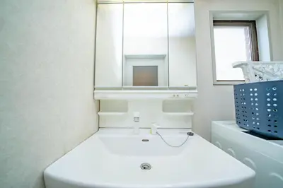 a white bathroom with a sink and a mirror at Hotel Atelier Tokyo in Tokyo