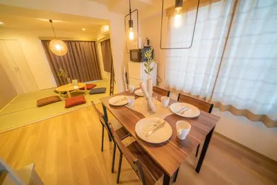 a dining room with a wooden table with chairs at Hotel Atelier Tokyo in Tokyo