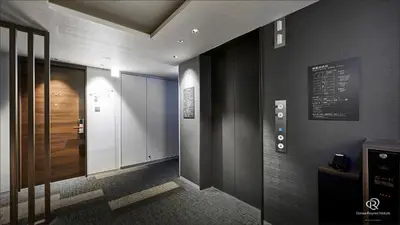 a hallway with a door and a sign on a wall at Daiwa Roynet Hotel Shimbashi in Tokyo