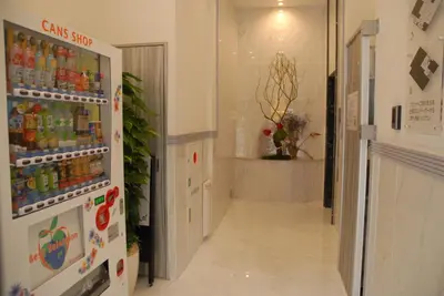 a hallway with a refrigerator filled with drinks at Okachimachi Urban Hotel in Tokyo