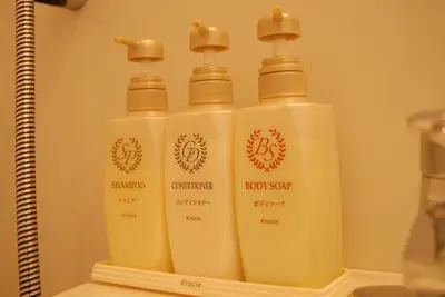 three bottles of soap on a shelf in a bathroom at Okachimachi Urban Hotel in Tokyo