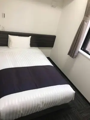 a small bedroom with a bed and a window at Okachimachi Urban Hotel in Tokyo