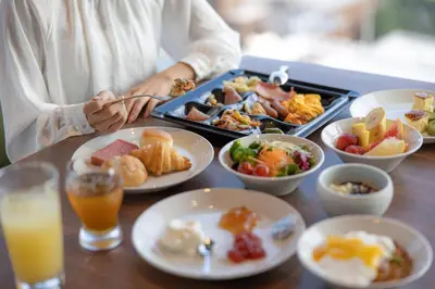 a person sitting at a table with a tray of food at THE BLOSSOM HIBIYA in Tokyo