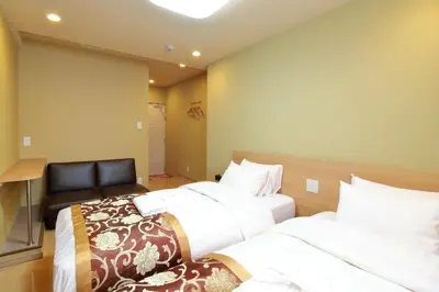 a bedroom with two beds and a chair in it at Arakawa-ku - Hotel / Vacation STAY 22248 in Tokyo
