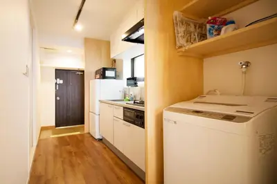 a small kitchen with a refrigerator and a dishwasher at Roppongi ClassyHouse902 in Tokyo