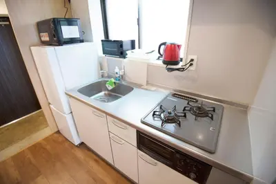 a small kitchen with a stove and a sink at Roppongi ClassyHouse902 in Tokyo