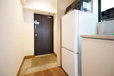 a kitchen with a white refrigerator and a door at Roppongi ClassyHouse902 in Tokyo