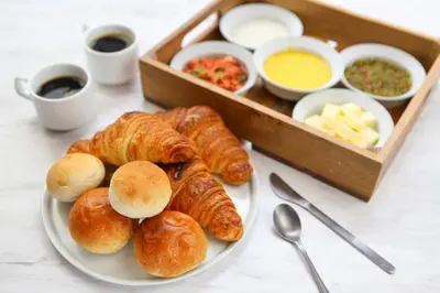 a plate of croissants and other pastries on a table at Via Inn Prime Nihonbashi Ningyocho in Tokyo