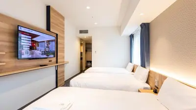 a hotel room with two beds and a flat screen tv at Via Inn Prime Nihonbashi Ningyocho in Tokyo