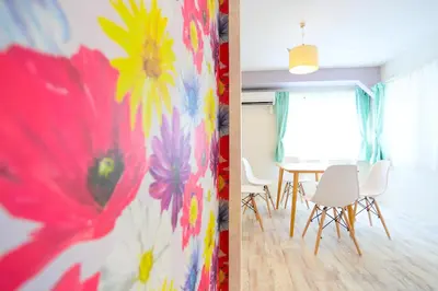 a dining room with a table and flowers on the wall at Villa Ikebukuro in Tokyo