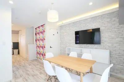 a dining room with a wooden table and white chairs at Villa Ikebukuro in Tokyo