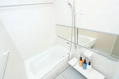 a white bathroom with a sink and a mirror at Villa Ikebukuro in Tokyo