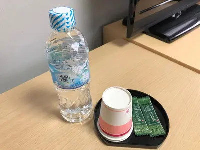 a bottle of water and a cup on a table at Business Hotel Sunpalace in Tokyo