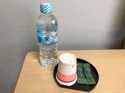 a bottle of water and a cup on a tray with a drink at Business Hotel Sunpalace in Tokyo