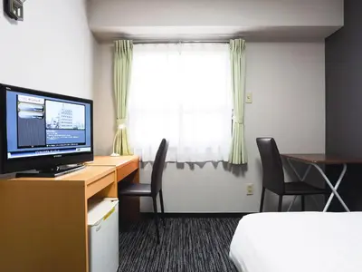 a hotel room with a desk with a computer and a window at Business Hotel Sunpalace in Tokyo