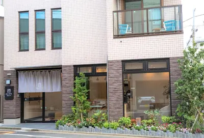 a brick building with windows and plants on a street at SOLA HOTEL in Tokyo