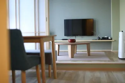 a living room with a table and a tv at SOLA HOTEL in Tokyo