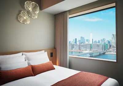 a bedroom with a window with a view of the city at Hotel JAL City Tokyo Toyosu in Tokyo