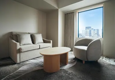 a living room with a couch and a chair and a table at Hotel JAL City Tokyo Toyosu in Tokyo