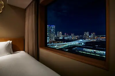 a bedroom with a view of a city at night at Hotel JAL City Tokyo Toyosu in Tokyo