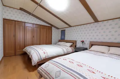 a bedroom with two beds and a ceiling at Hong house in Tokyo