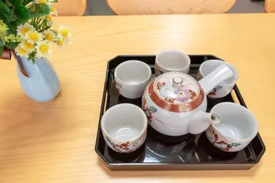 a tray with a group of tea cups and a vase at Hong house in Tokyo