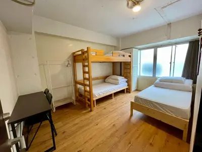 a small room with two bunk beds and a desk at Nomad Hostel East in Tokyo
