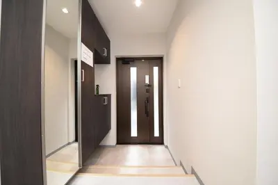 a hallway with a black door and a stairway at ACT one in Tokyo